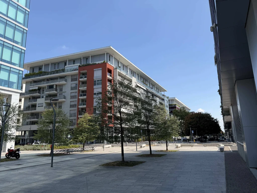 Moderni complessi residenziali e piazza pedonale alberata adiacente al distretto business Spark a Santa Giulia Milano.