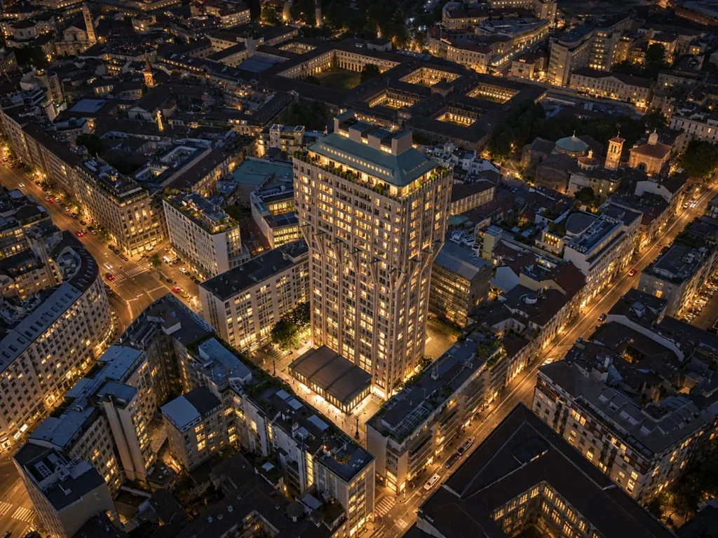 Vista aerea serale della Torre Velasca a Milano illuminata dopo il restauro, circondata dagli edifici del centro storico